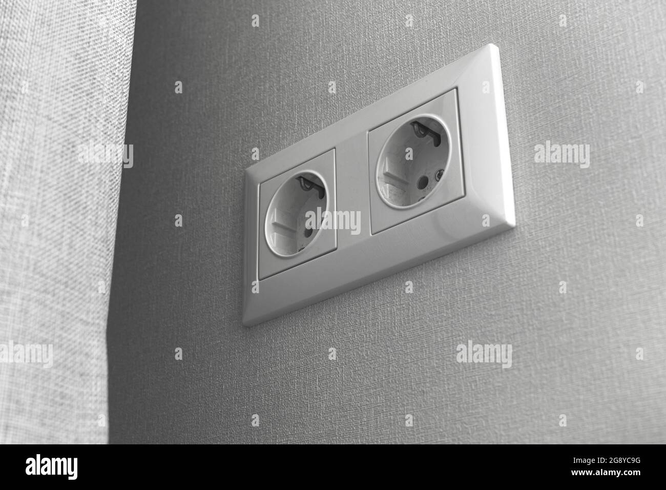 Double European electrical socket on wall at home in modern design, gray wall color Stock Photo