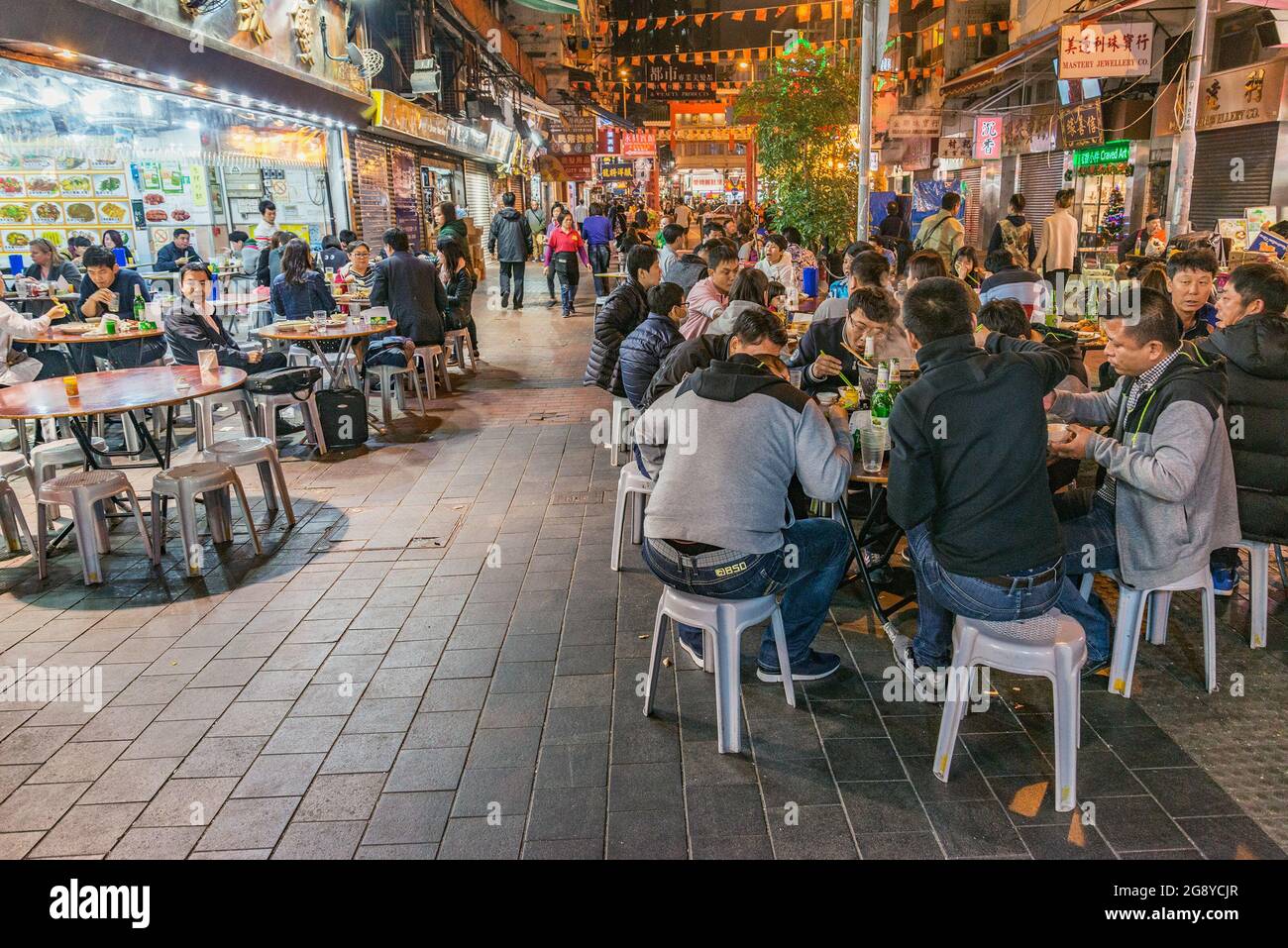 Hong Kong - December 15, 2016: People sit in the street cafes in Central city District at evening time. Stock Photo