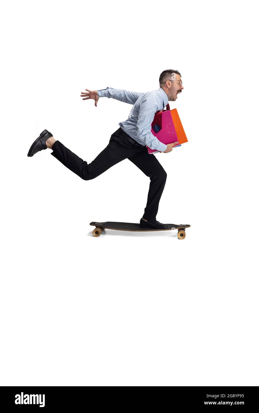 Late for meeting. Portrait of young Caucasian man, office worker rides on  skateboard isolated on white background Stock Photo - Alamy