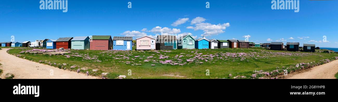 Panorama of beach huts all different and home made and so English at Portland Bill in Dorset England Stock Photo