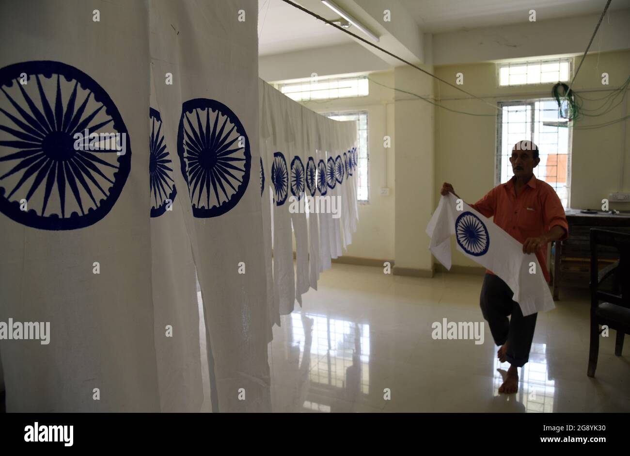 Guwahati, Guwahati, India. 23rd July, 2021. An employee of Assam Khadi and Village Industries Board drying the Ashoka Chakra portion of National Flag of India ahead of the celebration of Independence day at Assam Khadi and Village Industries Board in Guwahati Assam India on Friday 23rd July 2021. (Credit Image: © Dasarath Deka/ZUMA Press Wire) Stock Photo