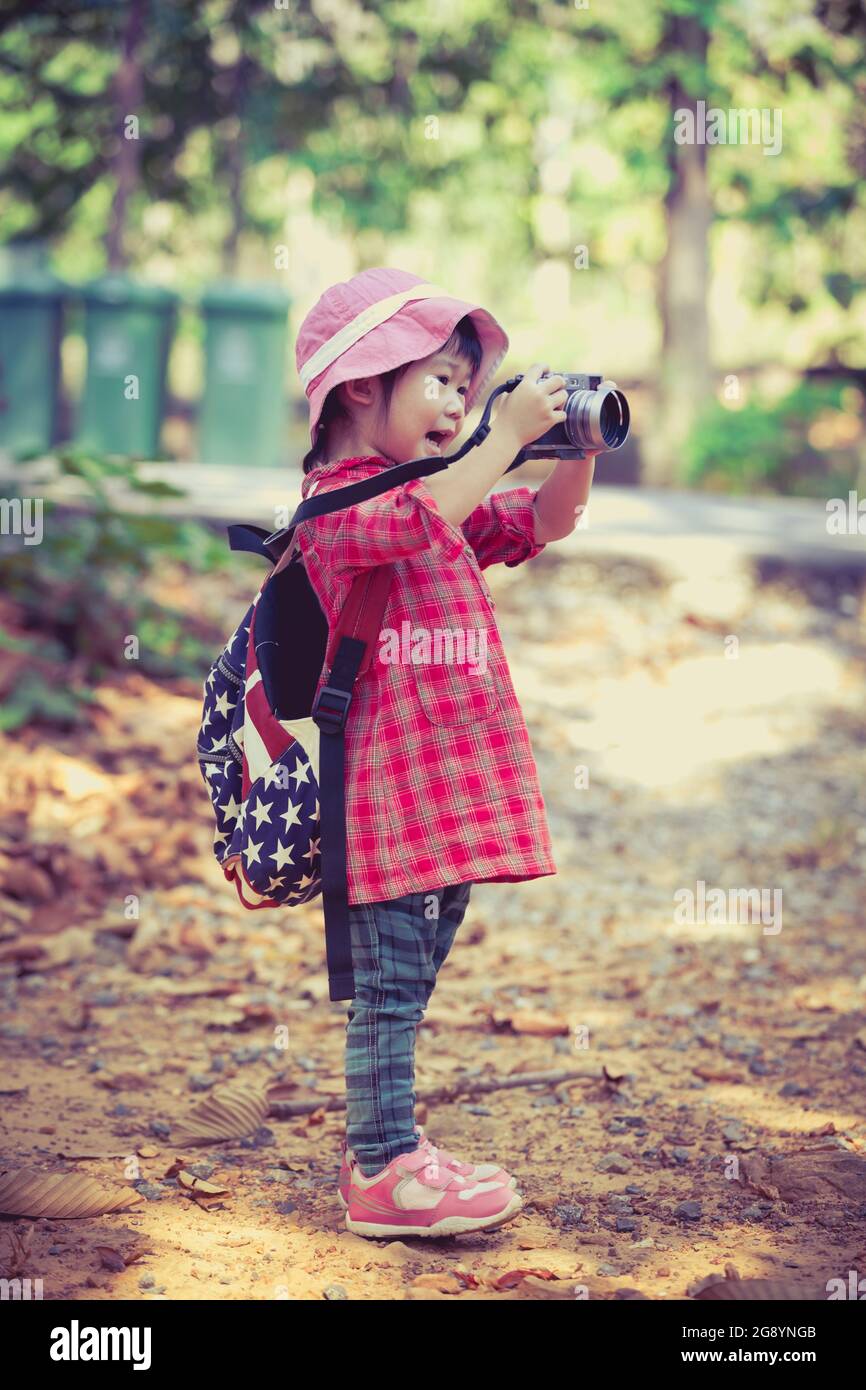 Cute Little Asian Girl Taking Photos By Professional Digital Camera In Garden Background Photo