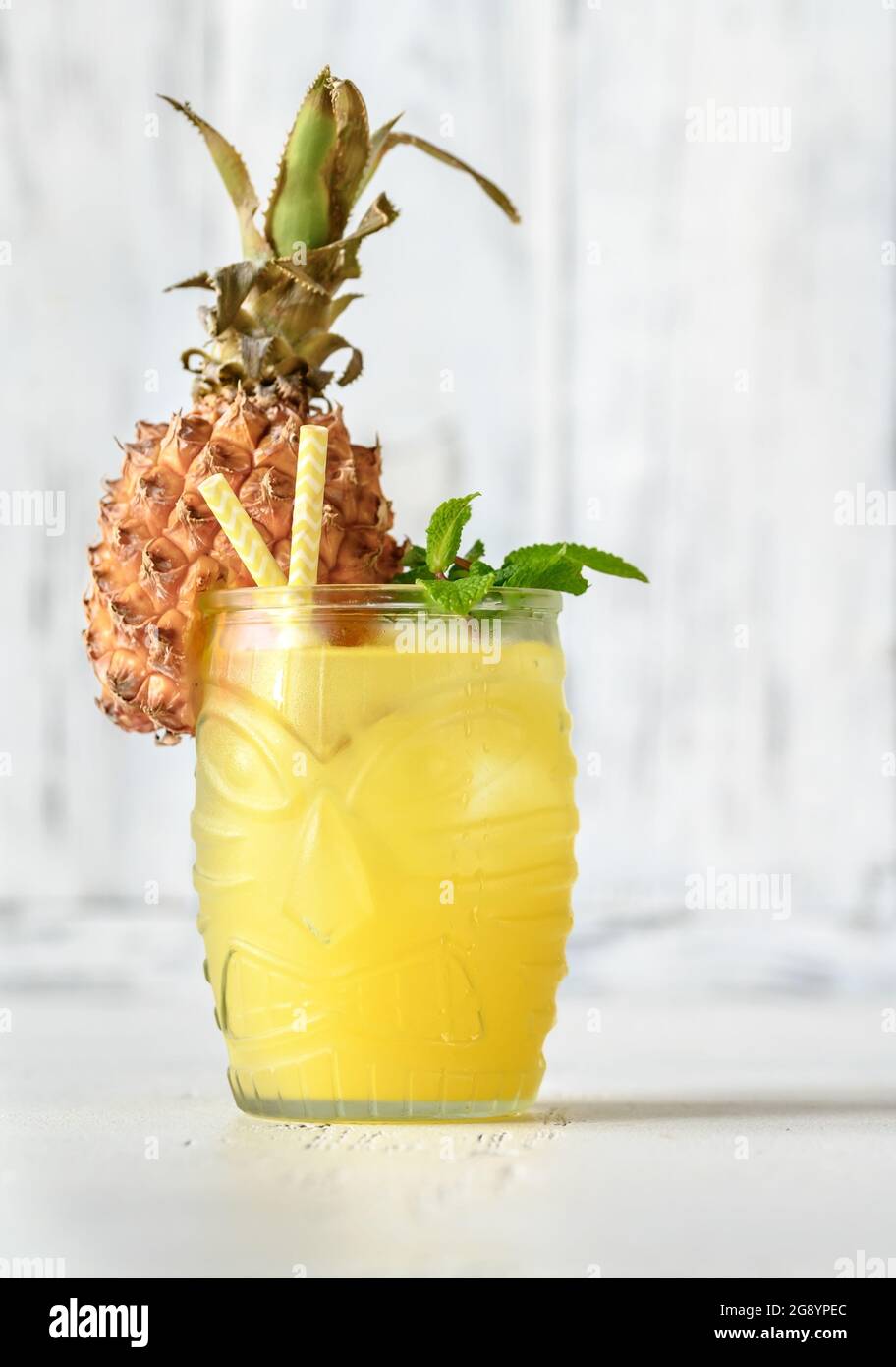 Glass of pineapple tiki style cocktail on white background Stock Photo
