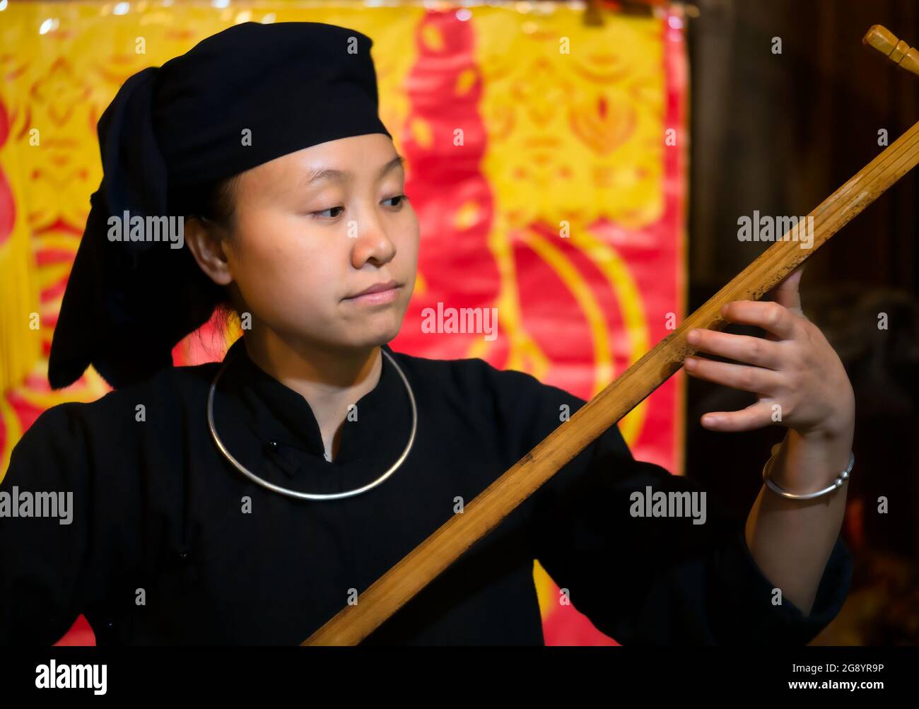 Young woman playing traditional music on lute at Thai Hai ethnic village, Thai Nguyen province, Northern Vietnam, Asia Stock Photo