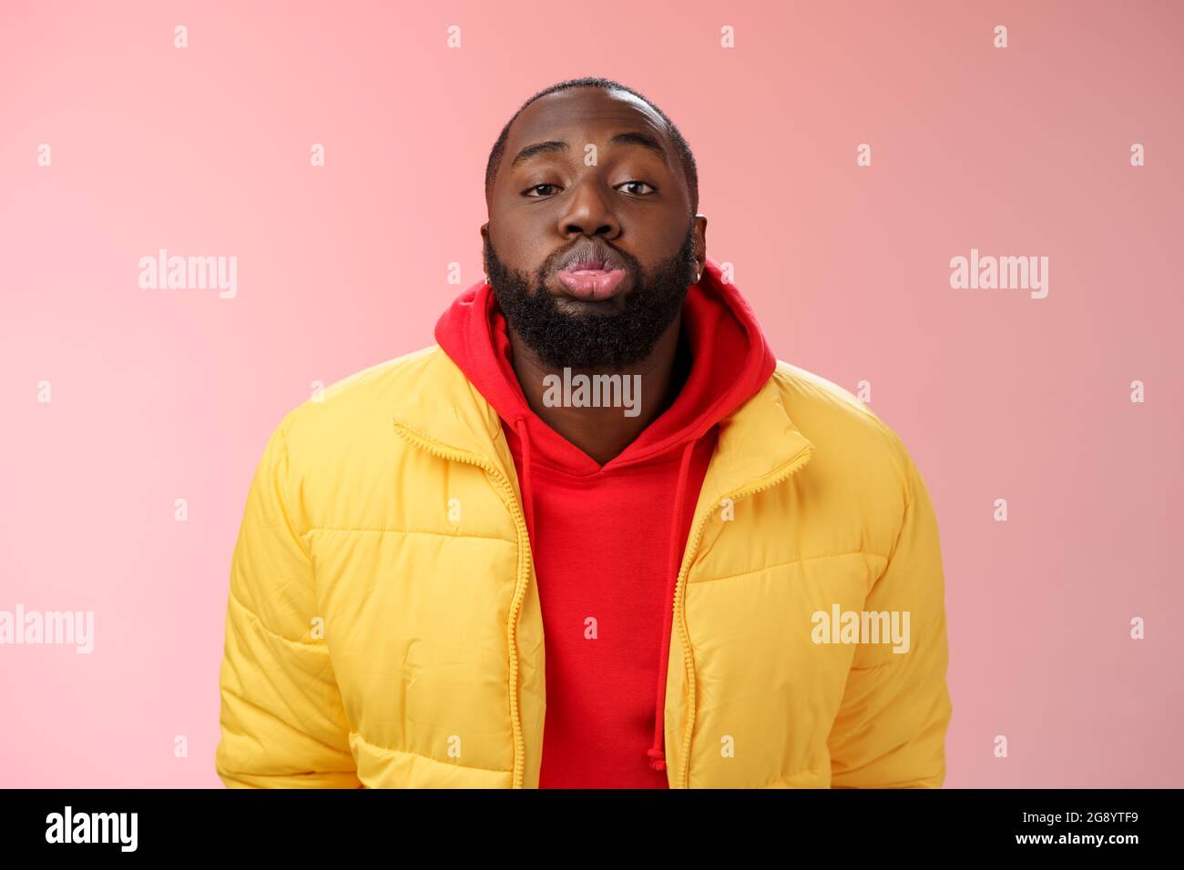 Portrait bored childish cute african bearded 25s male show tongue grimacing making funny faces immature behaviour unwilling grow-up standing pink Stock Photo