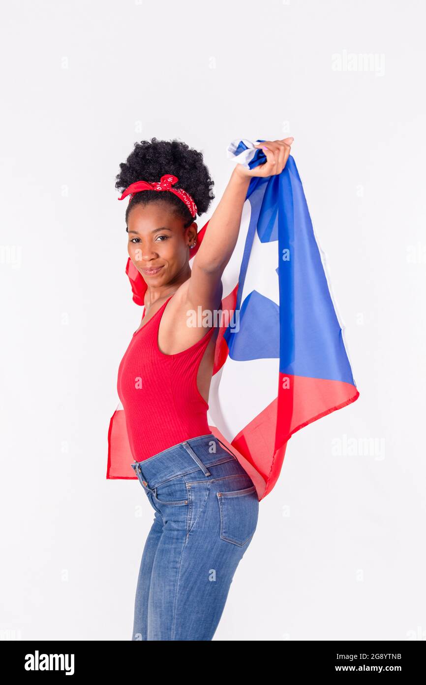 Latina woman dancing while holding the flag of Puerto Rico: Patriotic concept Stock Photo