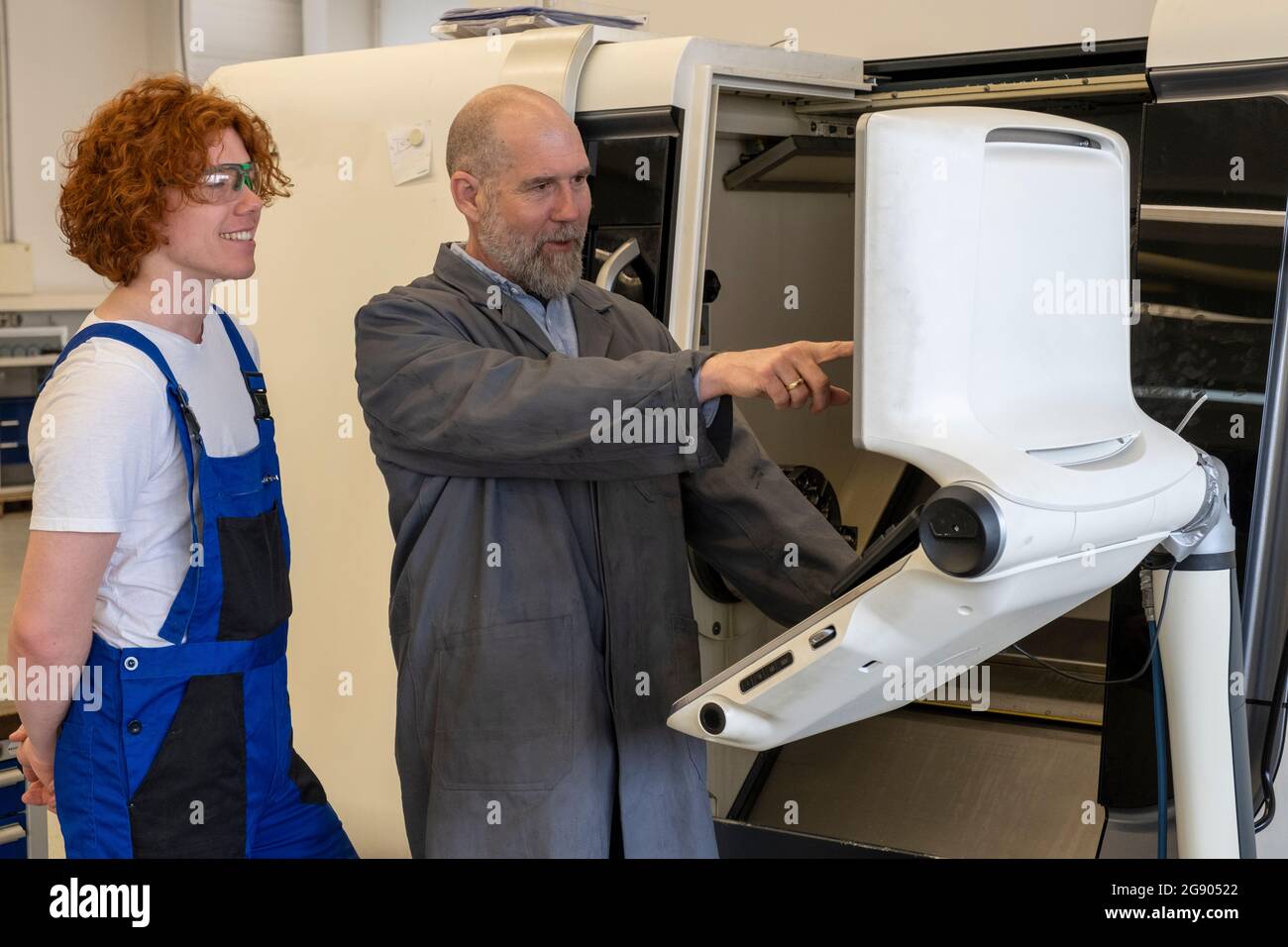 Mature male instructor guiding young technician at industry Stock Photo