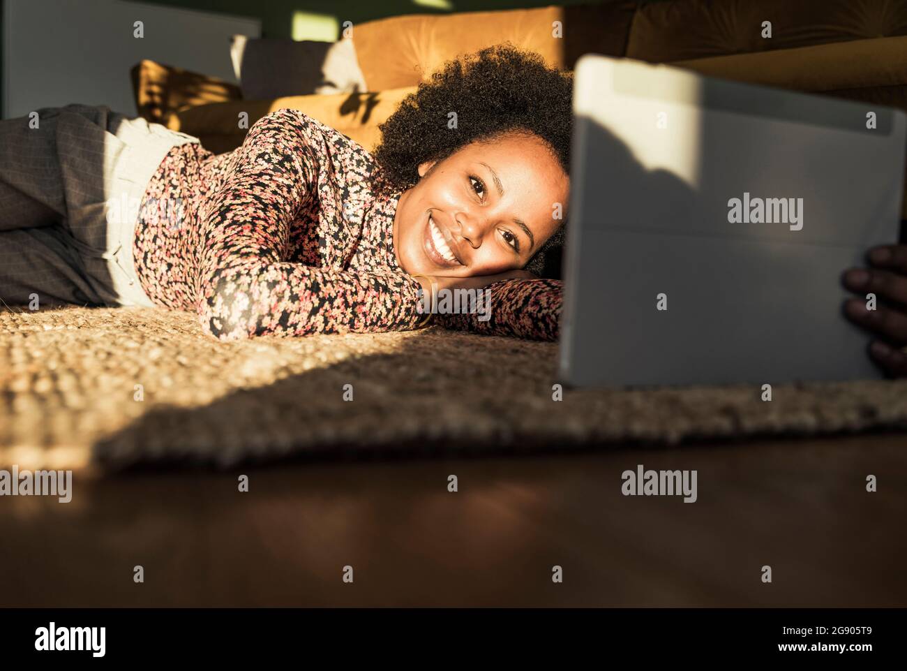 Woman smiling while using digital tablet at home Stock Photo