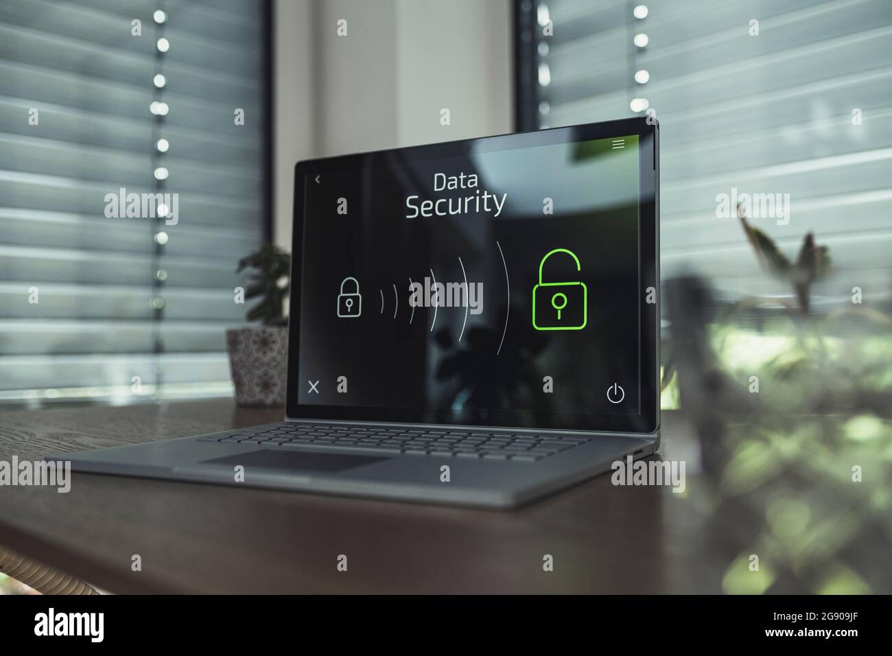Laptop with data security icons on table at home Stock Photo