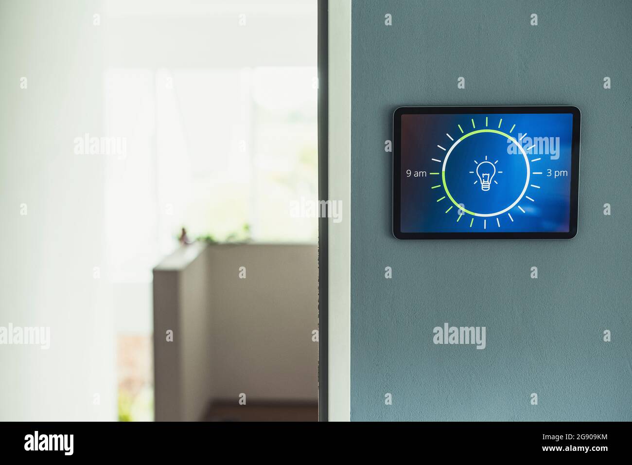 Home automation with light bulb icon on screen mounted on wall at home Stock Photo