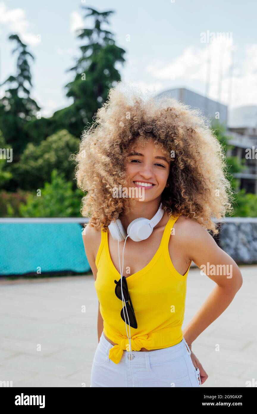 Beautiful smiling woman standing with hands on hip Stock Photo - Alamy
