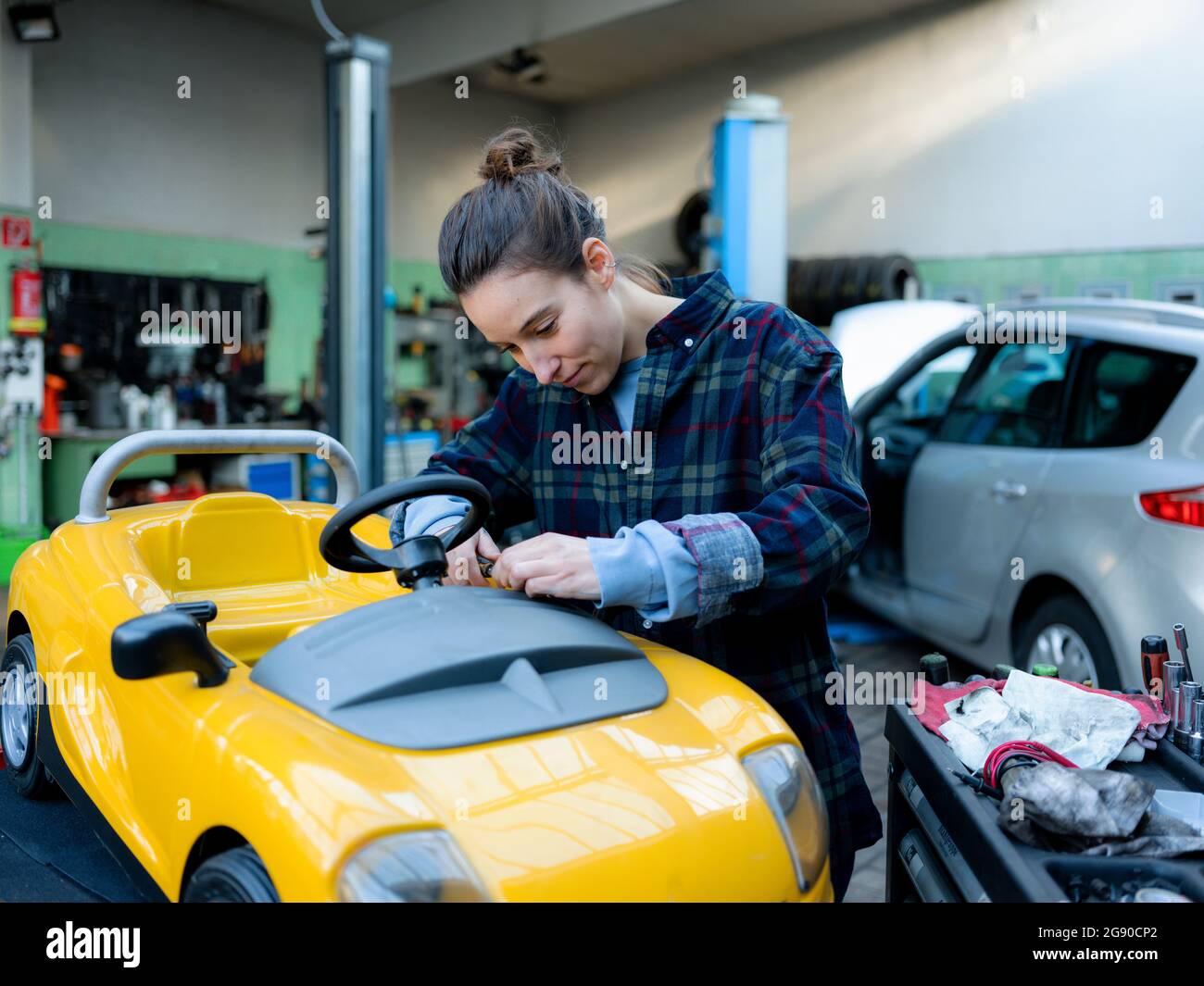 Female mechanic repairing toy car at Stock Photo Alamy