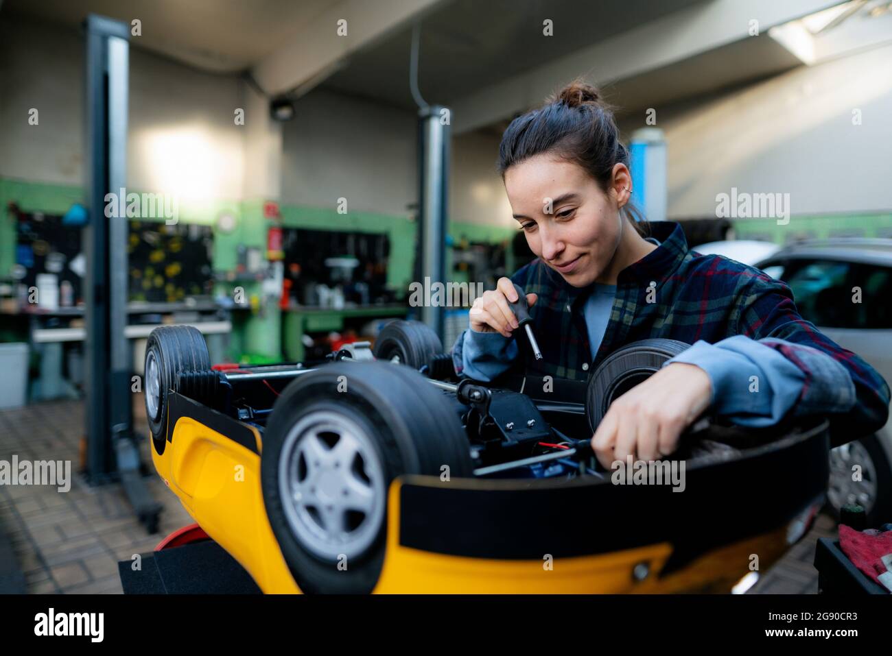 Female mechanic repairing toy car at Stock Photo Alamy