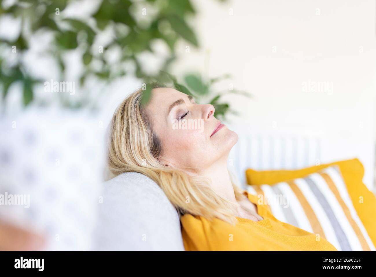 Woman with eyes closed relaxing at home Stock Photo - Alamy