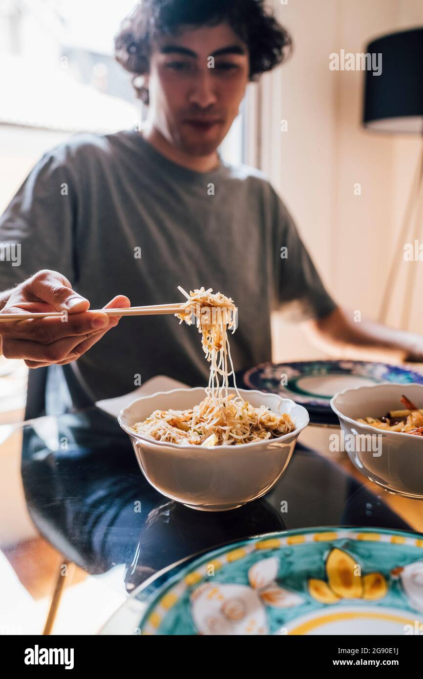 Man having lunch while sitting by dining table at home Stock Photo