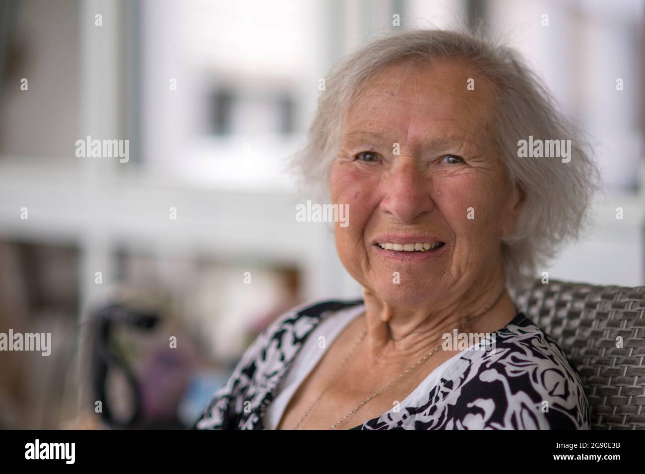 Smiling senior woman sitting on chair Stock Photo - Alamy