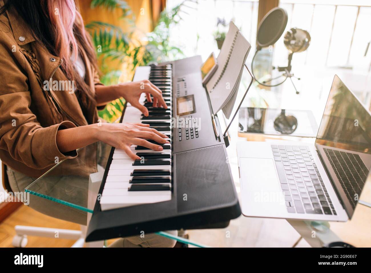 Female musician playing electric piano at home Stock Photo