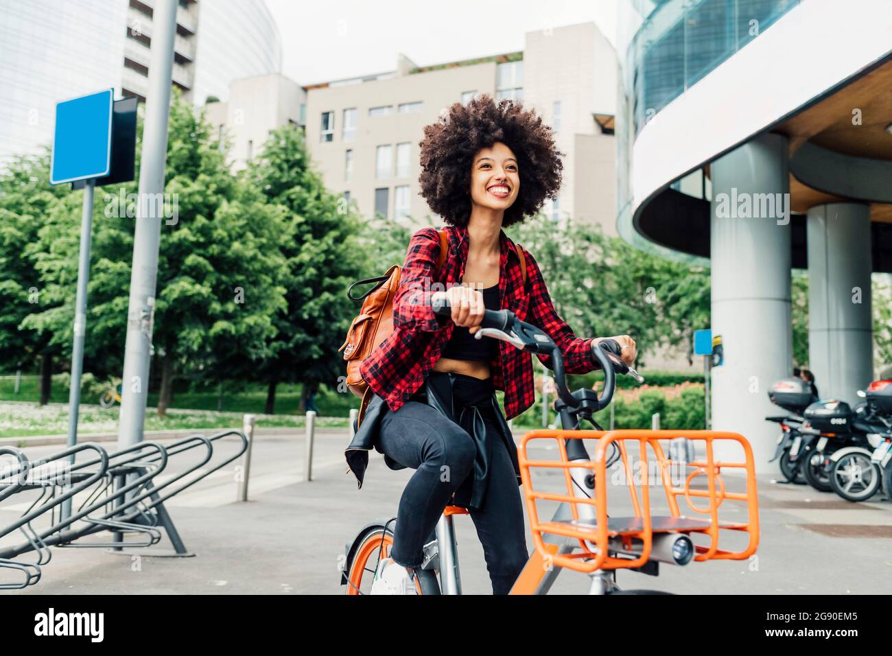 Cheerful young woman cycling in city Stock Photo