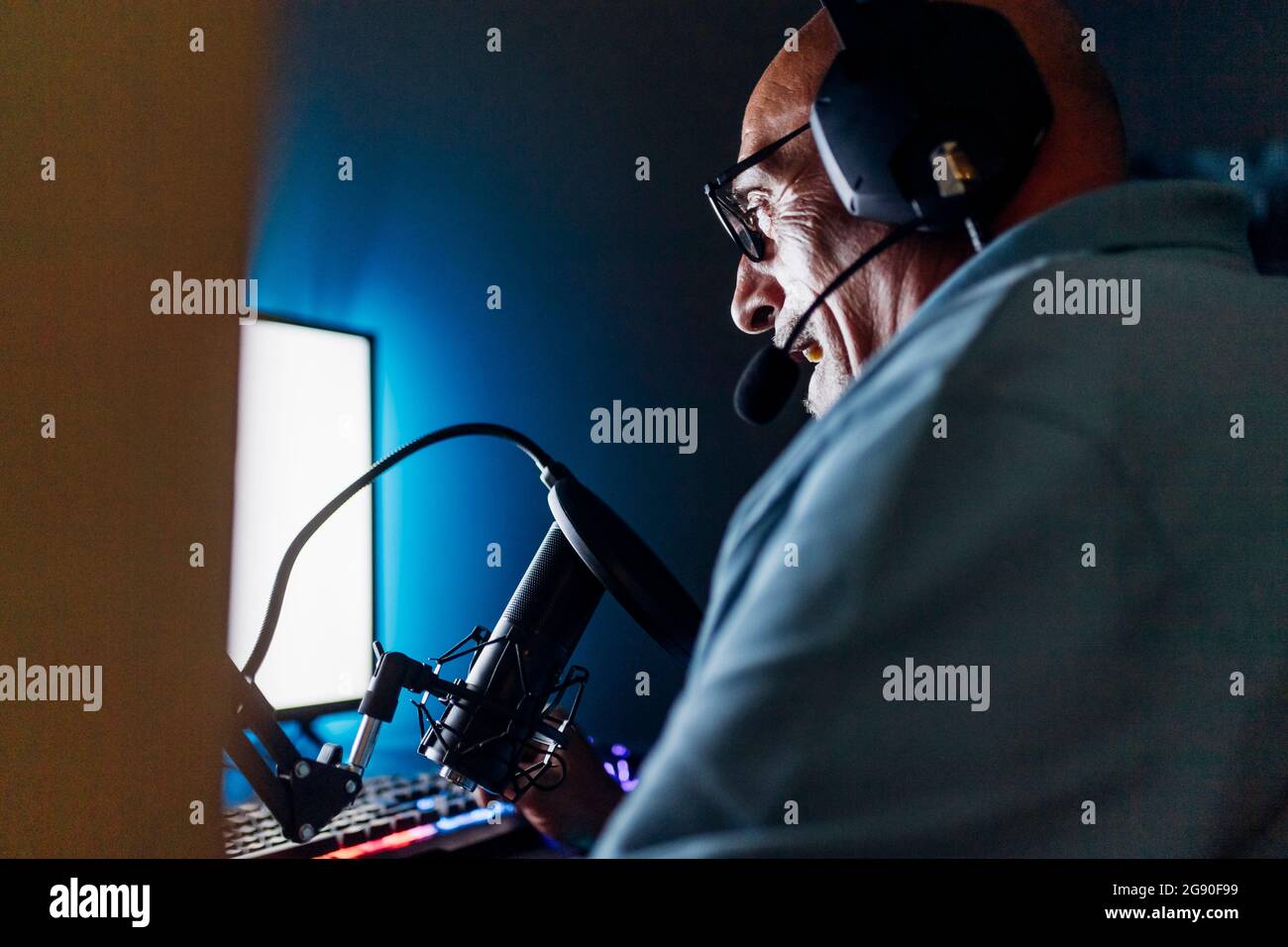 Man live streaming while using computer at home Stock Photo