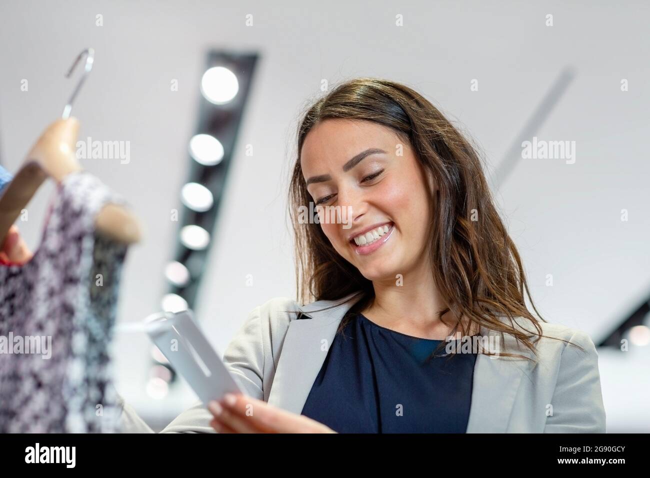 Smiling woman looking at price tag in boutique Stock Photo