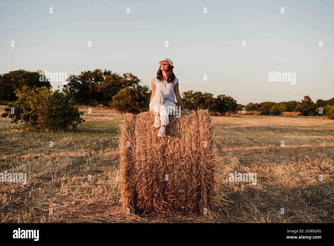 Woman wearing straw hat sitting hi-res stock photography and images - Alamy