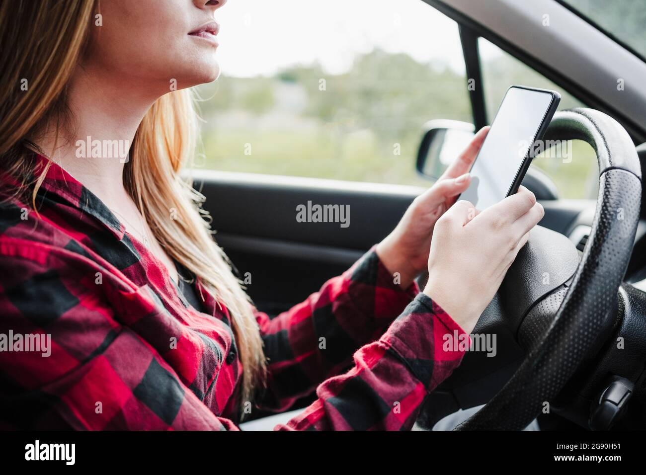 Young woman using smart phone in car Stock Photo