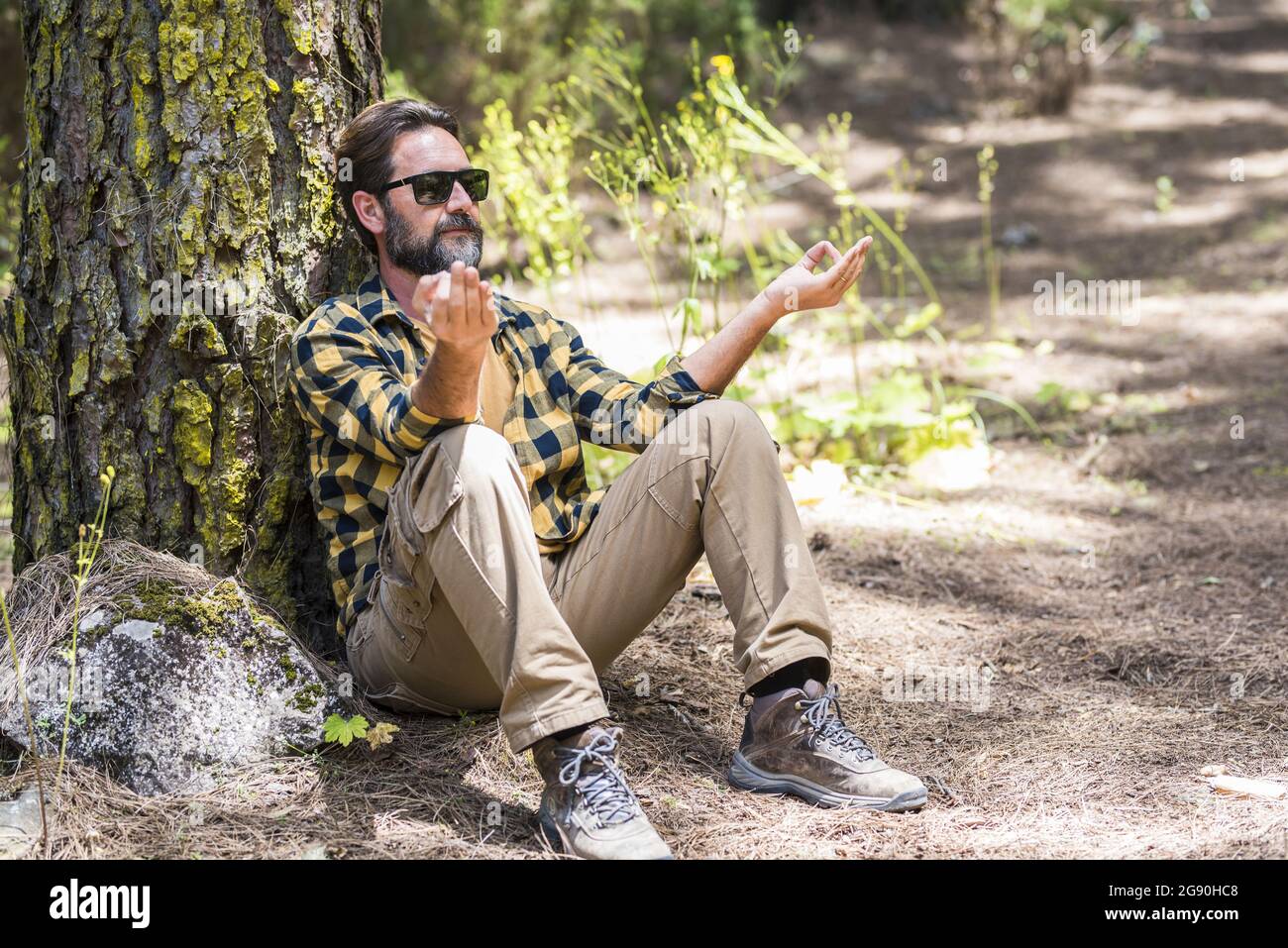 Man doing relaxation exercise in forest Stock Photo
