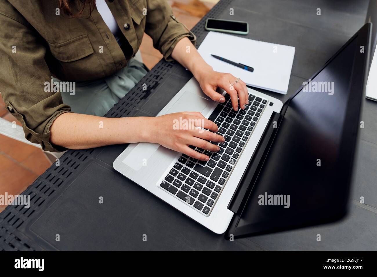 Female freelancer using laptop while sitting at desk Stock Photo