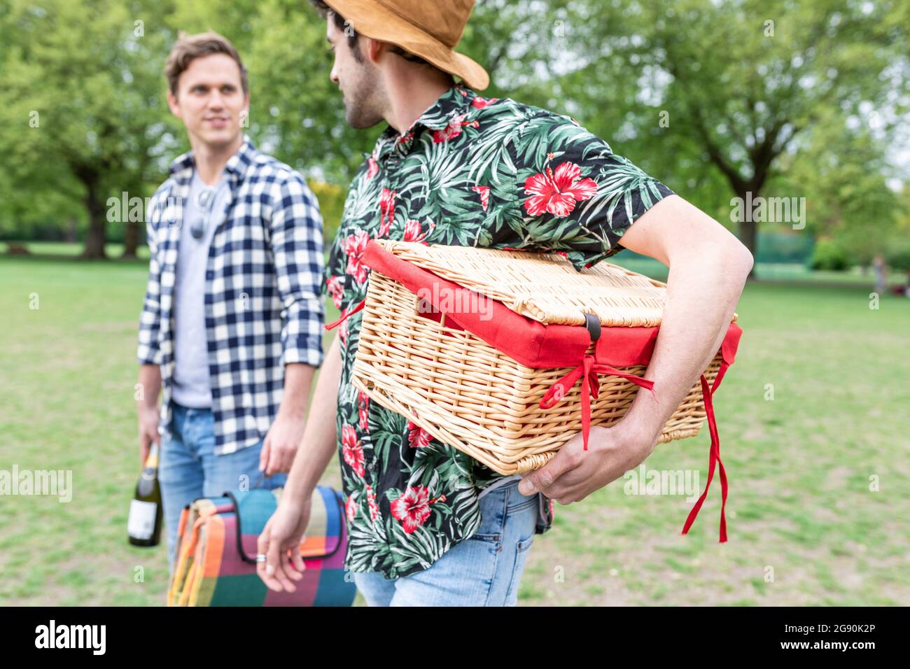 Man carrying basket while talking with friend at park Stock Photo