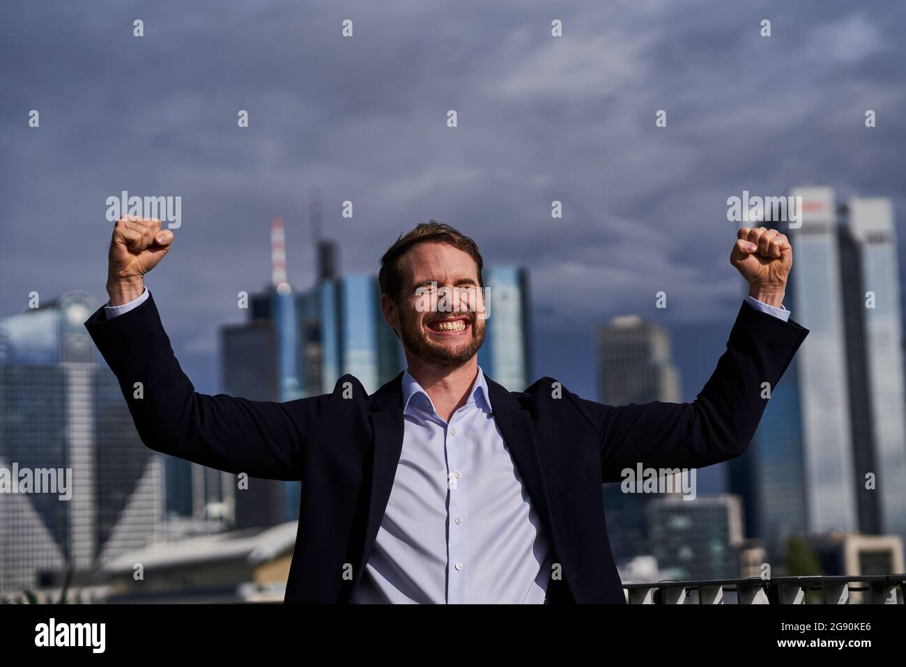 Happy businessman with hands raised at rooftop Stock Photo - Alamy