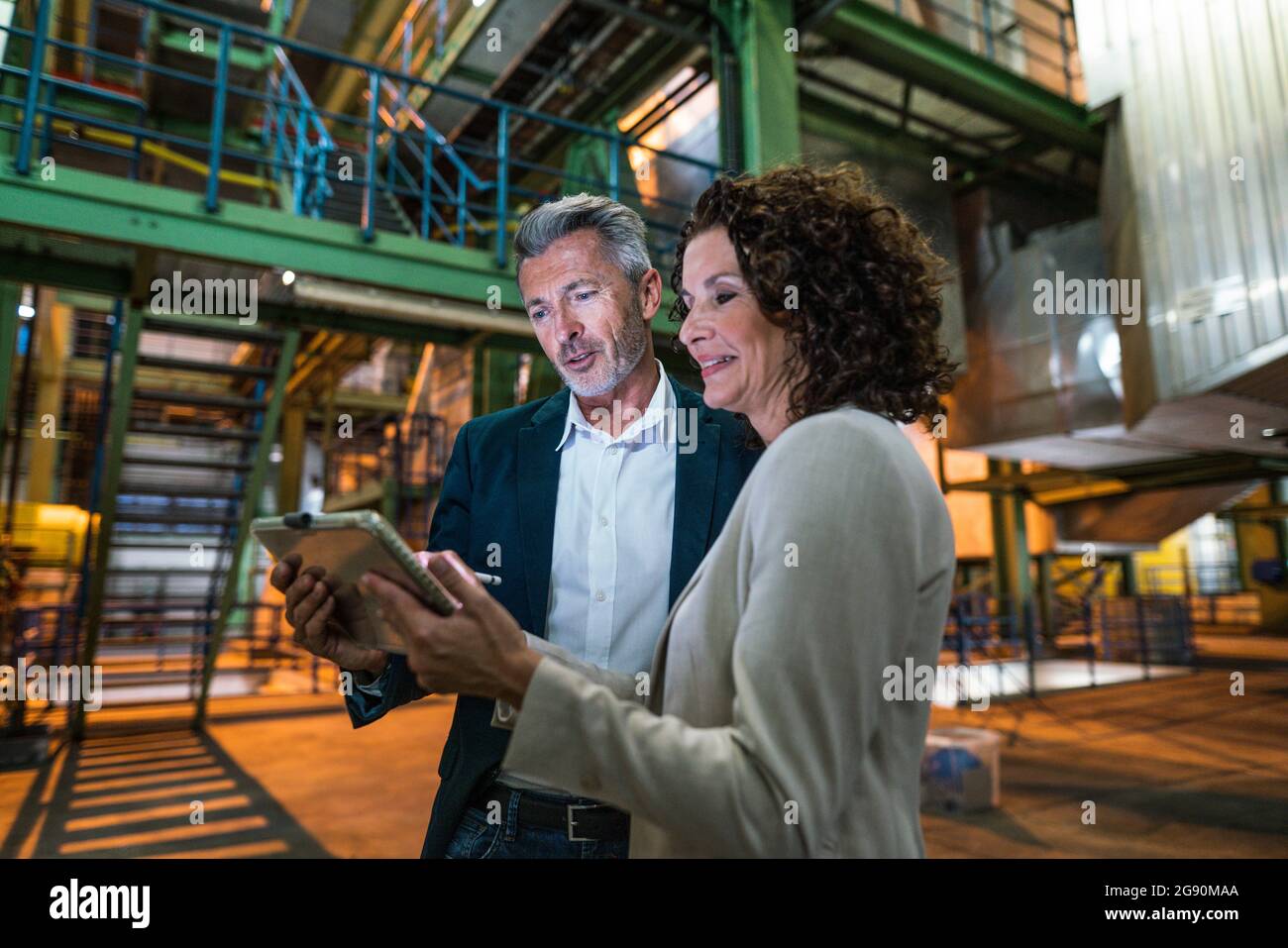 Professional team using digital tablet while standing in industry Stock Photo