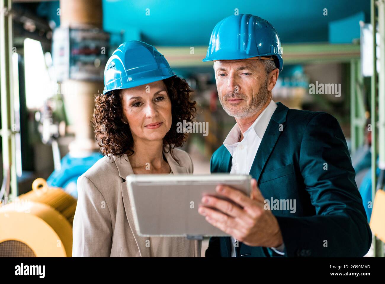 Expertise team with hardhat using digital tablet in industry Stock Photo