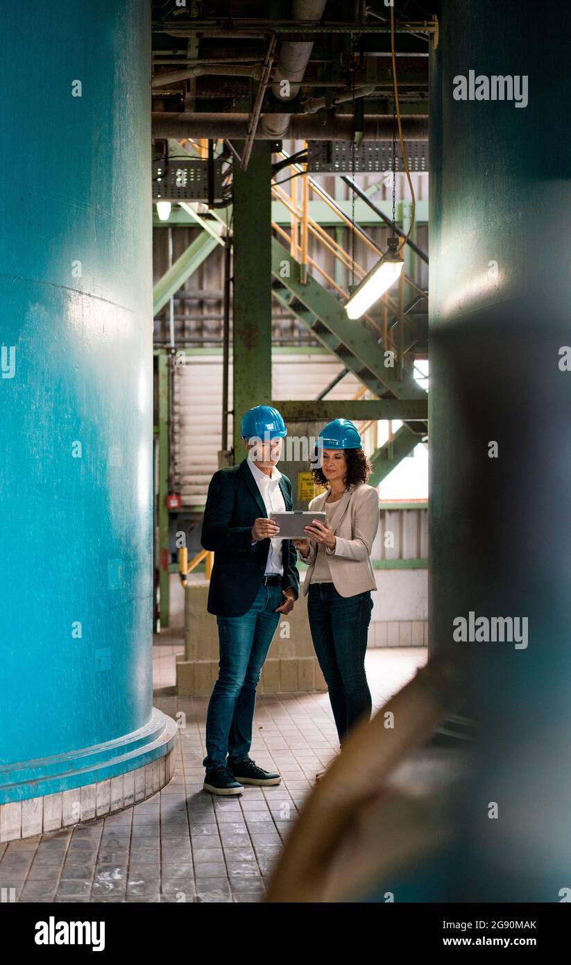 Expertise team with hardhat using digital tablet in workshop Stock Photo