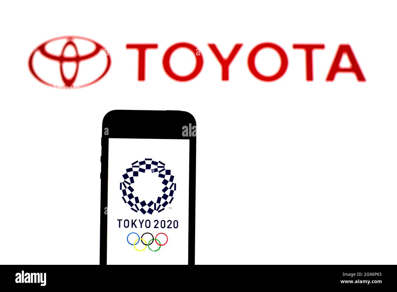 In this photo illustration a Tokyo 2020 Olympic Games logo seen displayed on a smartphone with a Toyota Motor logo in the background. Stock Photo