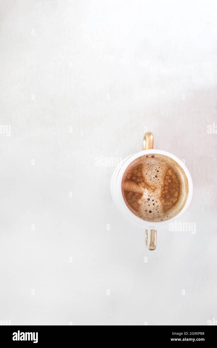 cup with cappuccino coffee on a light white retro sloppy fabric background. Copy space. Flat lay, top view. Minimalism. Stock Photo