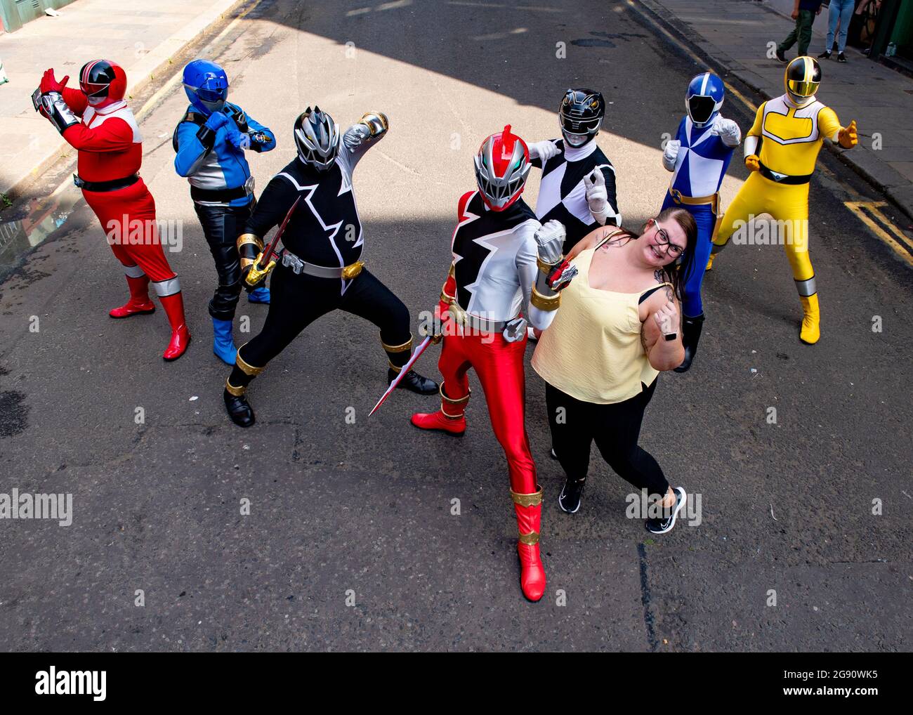 Glasgow, Scotland, UK. 23rd July, 2021. PICTURED: Power Rangers move into town as the Indiana Jones 5 movie set filming moves out. Seen in the Merchant City district of Glasgow city centre on one of the hottest days of the year, the people who are under the power rangers suits must be sweltering in the afternoon heat. The Power Ranger group go round hospitals in Glasgow and do charity work putting smiles on everyones faces. Credit: Colin Fisher/Alamy Live News Stock Photo