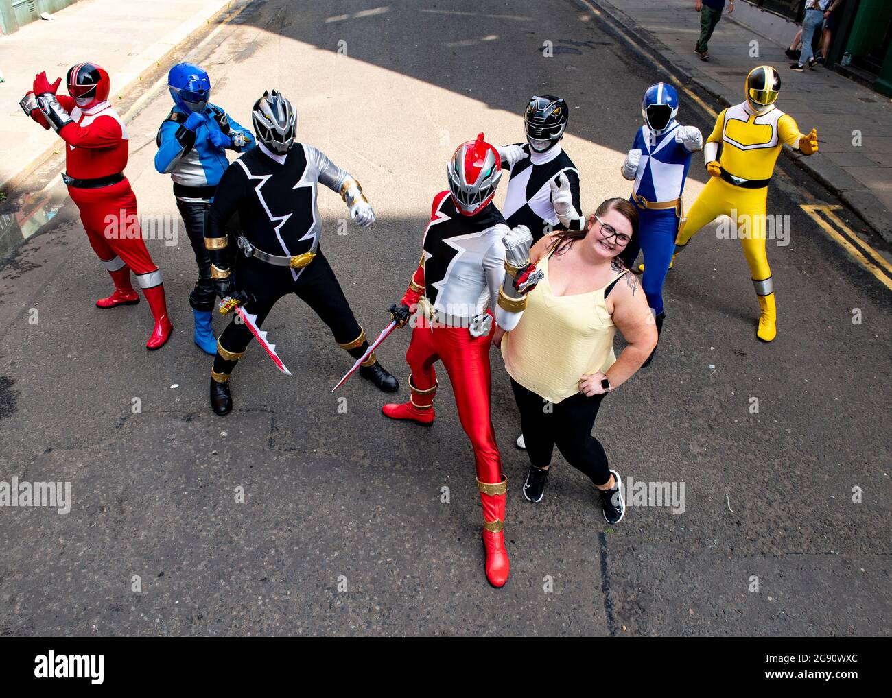 Glasgow, Scotland, UK. 23rd July, 2021. PICTURED: Power Rangers move into town as the Indiana Jones 5 movie set filming moves out. Seen in the Merchant City district of Glasgow city centre on one of the hottest days of the year, the people who are under the power rangers suits must be sweltering in the afternoon heat. The Power Ranger group go round hospitals in Glasgow and do charity work putting smiles on everyones faces. Credit: Colin Fisher/Alamy Live News Stock Photo