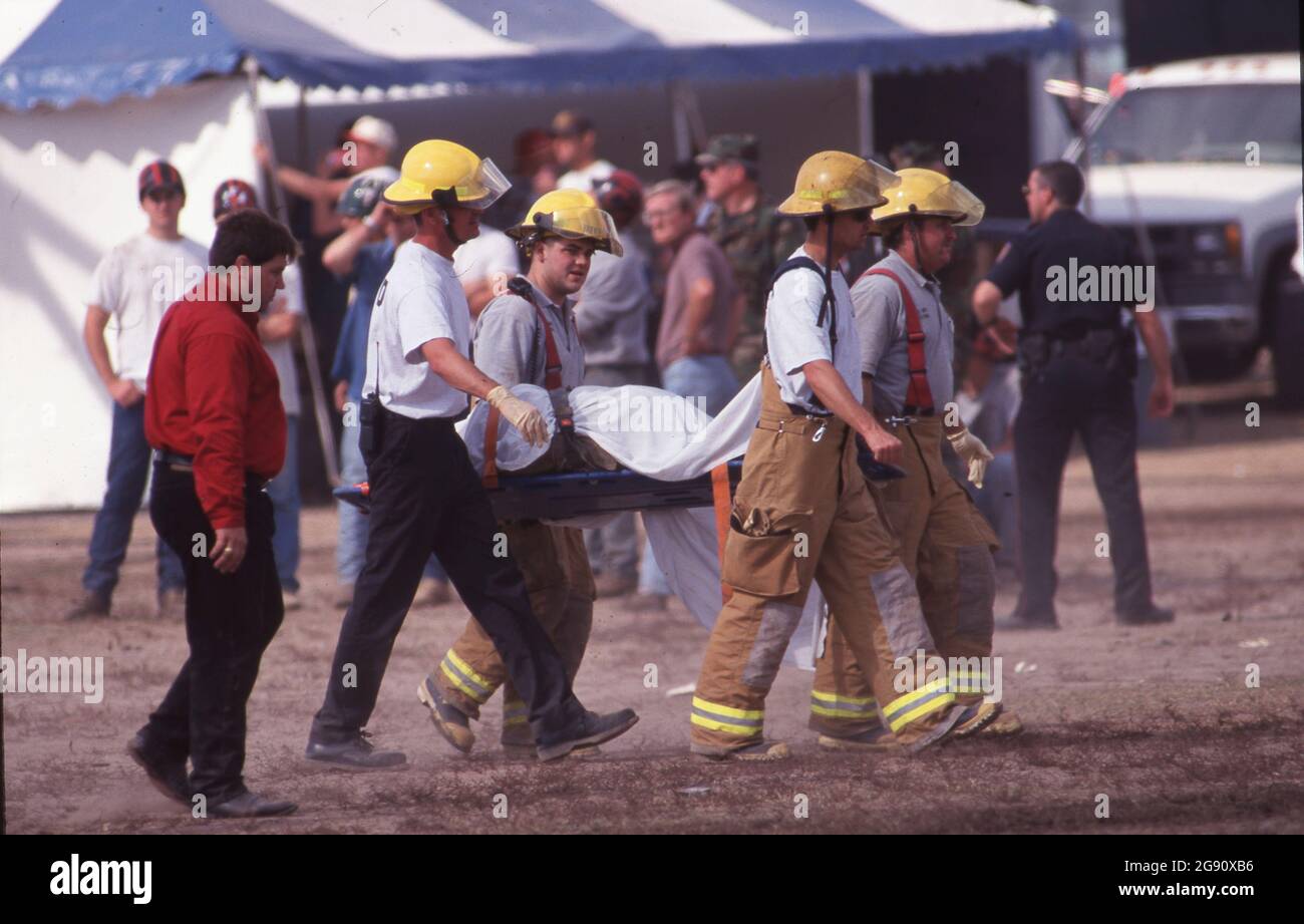College Station Texas USA, November  18 1999: Emergency responders remove the body of a victim just hours after the Aggie Bonfire collapse that killed 12 people building the stacks. Bonfire is a student-led ritual at the campus that has been part of school spirit activities leading up to the annual Texas-Texas A&M football game for decades. ©Bob Daemmrich Stock Photo