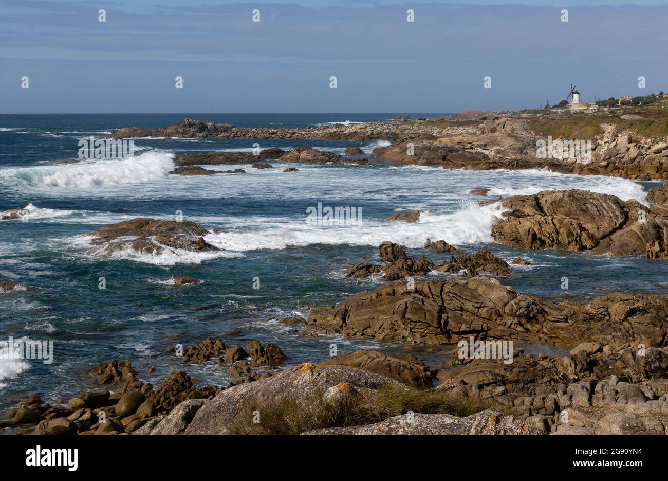 Vista de la costa de Oia con el océano Atlántico y un molino de viento. Stock Photo