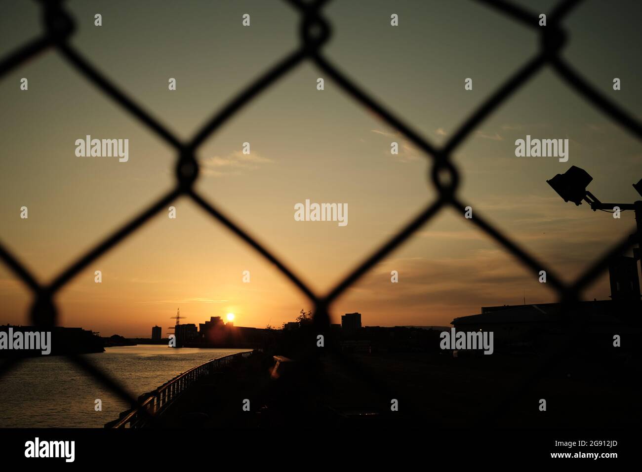 Fence covered sunset. Looking over the River Clyde, Glasgow. Summer 2021. Stock Photo