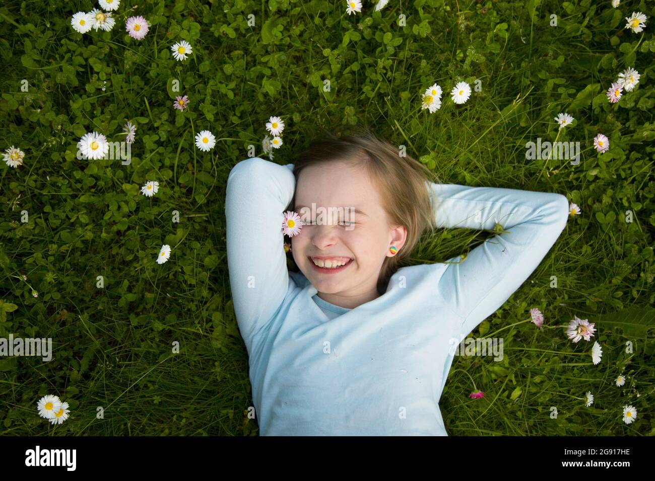 Portrait of a cheerful girl lying in the grass Stock Photo - Alamy