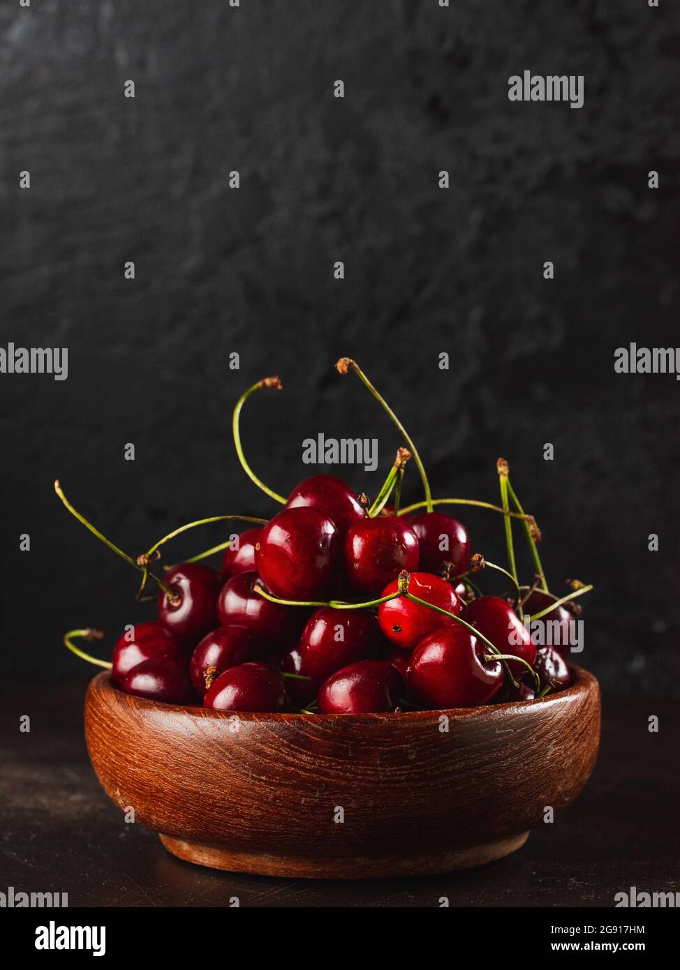 Cherie on dark background / Focused fresh cherie on stone plate Stock Photo