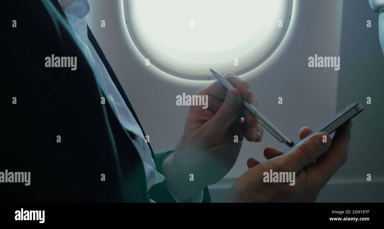Businessman using smart phone during the flight Stock Photo