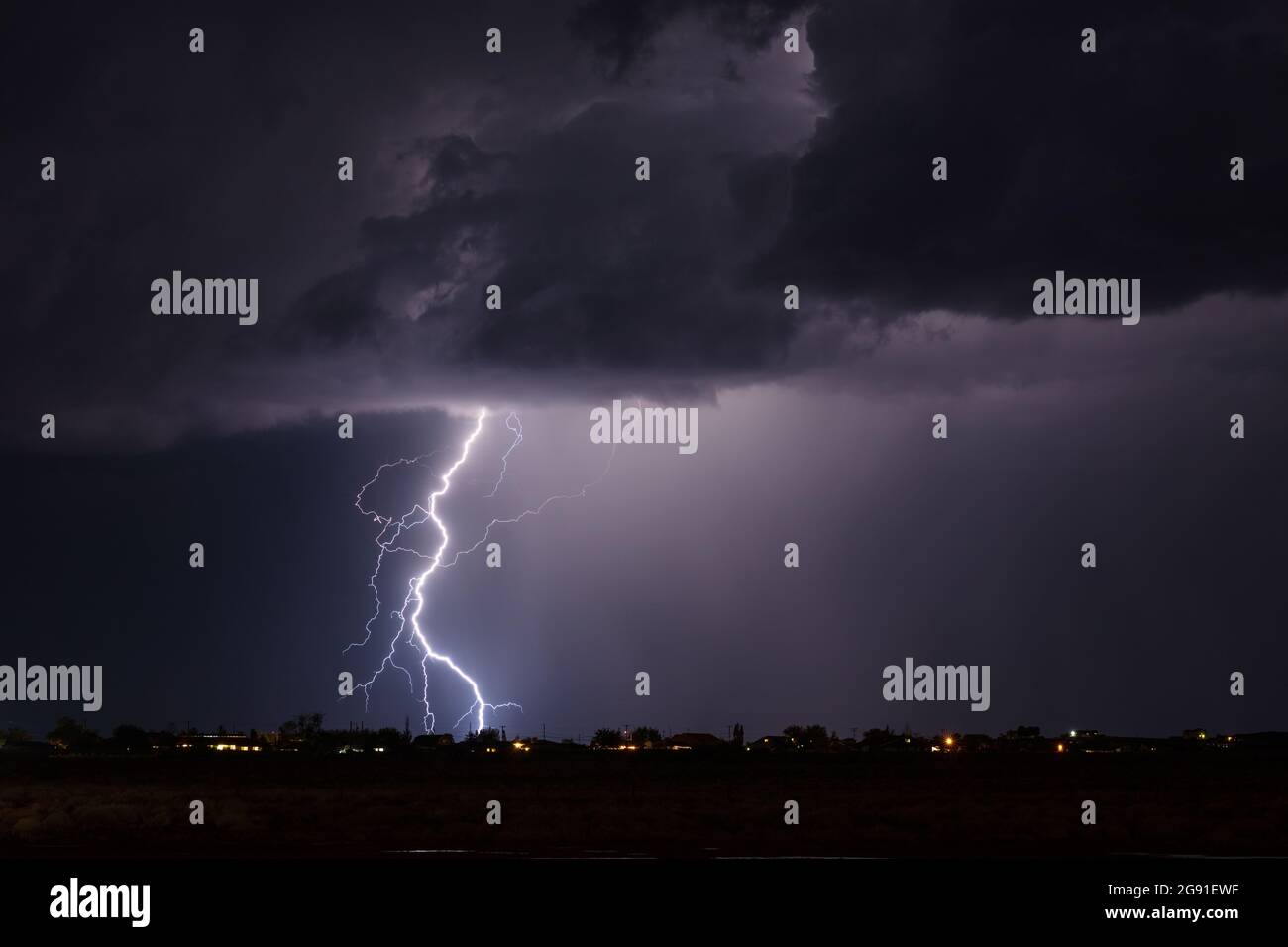 A lightning bolt strikes in a monsoon thunderstorm over Winslow, Arizona Stock Photo