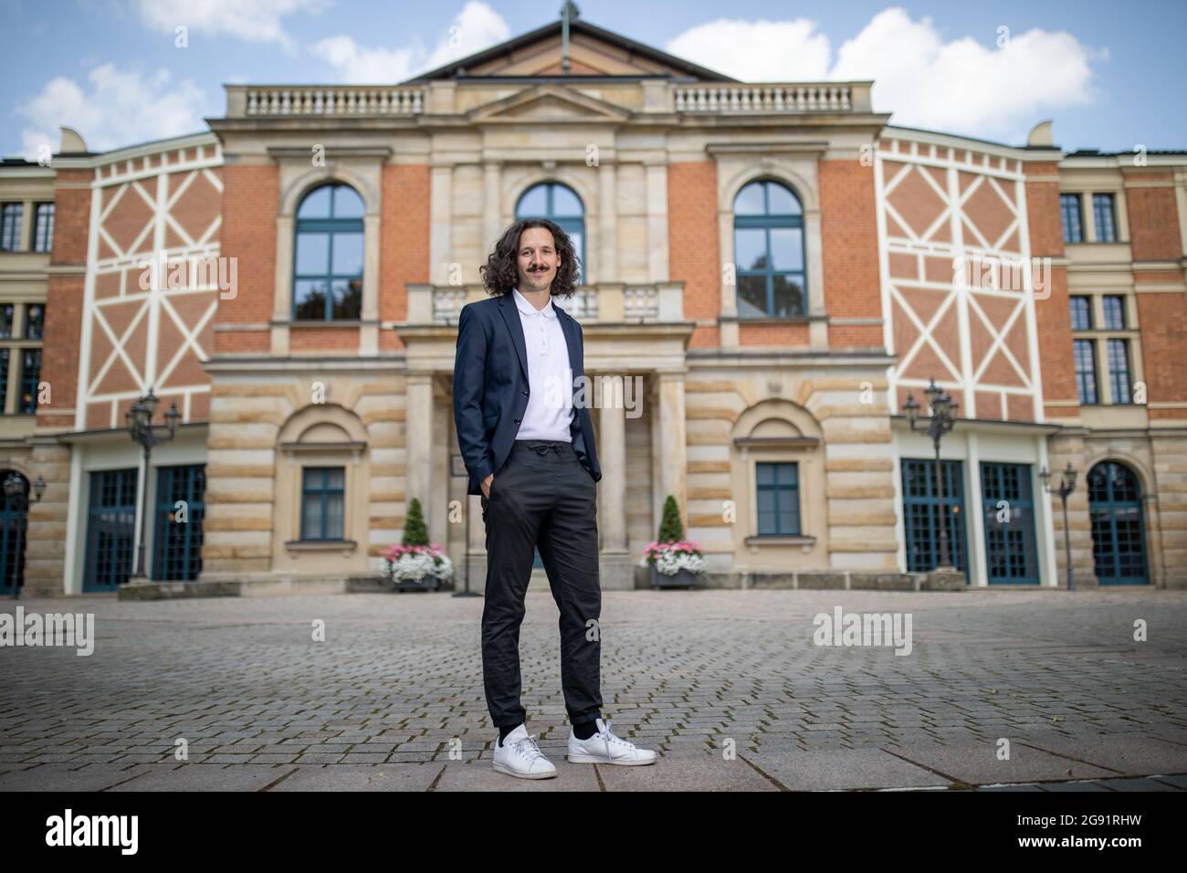 Bayreuth, Germany. 23rd July, 2021. The director Valentin Schwarz stands in  front of the Festspielhaus. The "Ring" director Schwarz, whose production  of the "Ring des Nibelungen" was supposed to premiere in 2020