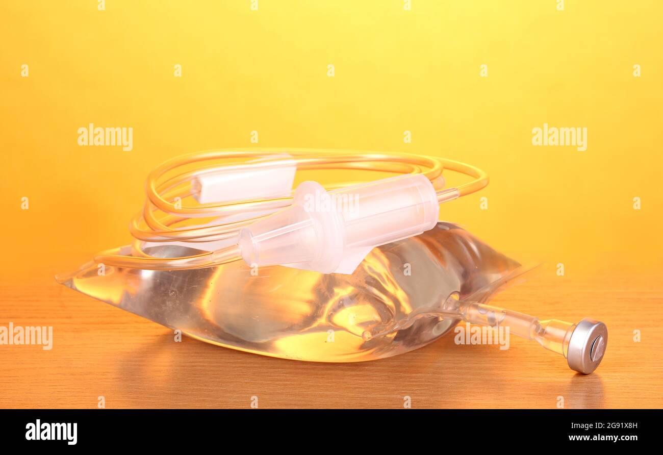 Bag of intravenous antibiotics and plastic infusion set on wooden table