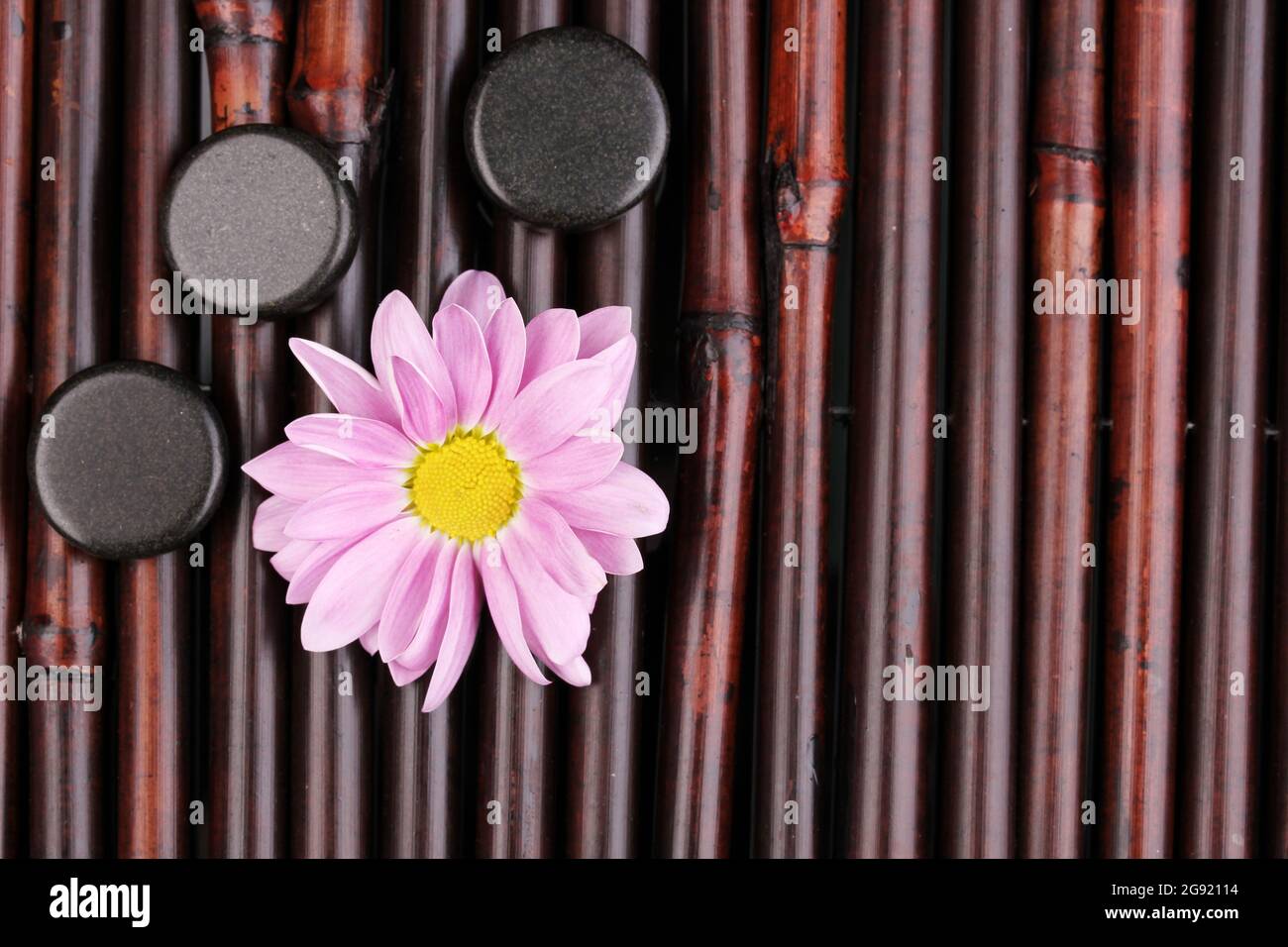 Spa stones and flower on bamboo mat Stock Photo - Alamy