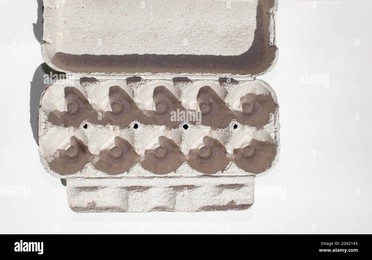 Grey egg carton without eggs on white background.  Stock Photo