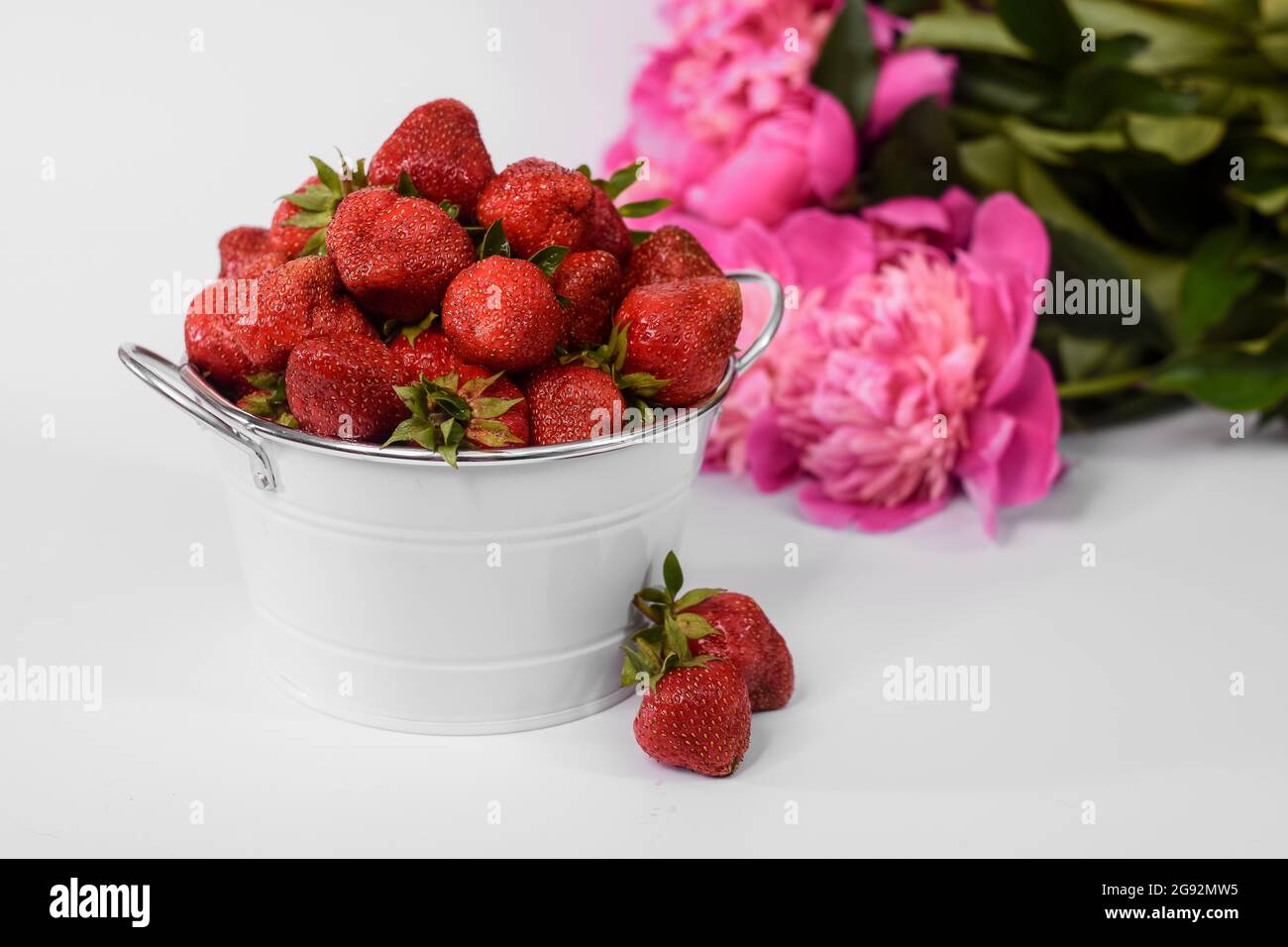 strawberries in a bucket on a white background Stock Photo - Alamy