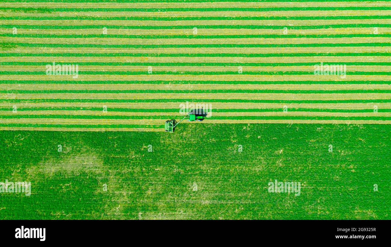 Above top view on tractor as pulling grass cutting machinery over field